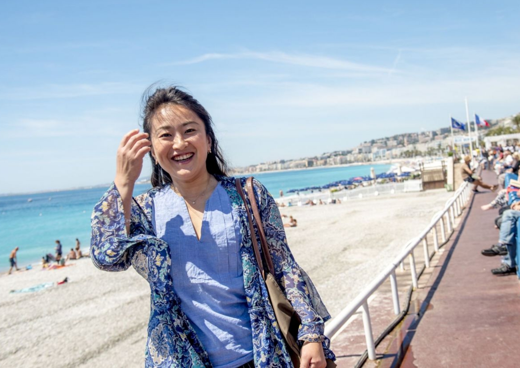 フランスの海岸で笑顔の女性が写っている写真