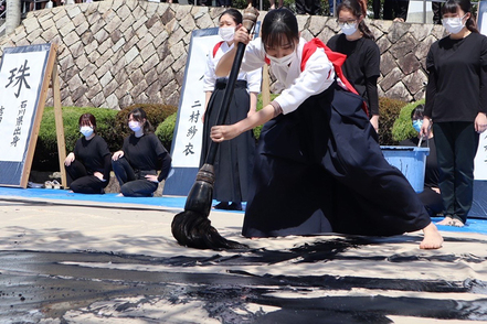 岐阜女子大学 入学式では新入生歓迎の意味を込め縦３ｍ×横１６ｍの白布に毎年、書道パフォーマンスを行います