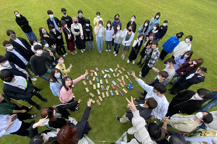 横浜美術大学 1年次には横断的に様々な分野の授業を展開。段ボールから制作したお財布を天然芝のグラウンドに並べて記念撮影！