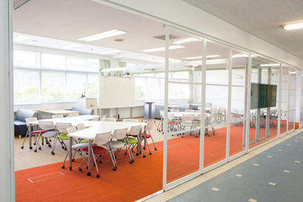 姫路獨協大学 スライドパネルとガラススチールを使用した透明な壁面のオープン教室「地域コラボレーションルーム」は大学と地域の共学の場。