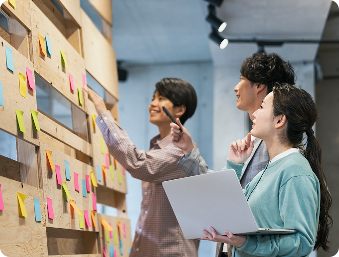 壁に付箋を貼ってアイデアを出しあう学生たち
