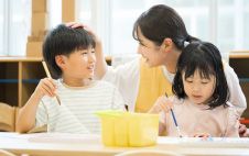 子どもと絵を描く先生の写真