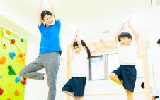 子どもと体操をする先生の写真